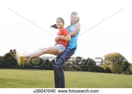 Mother swinging her daughter around View Large Photo Image Stock Image - Mother swinging her daughter around . Fotosearch