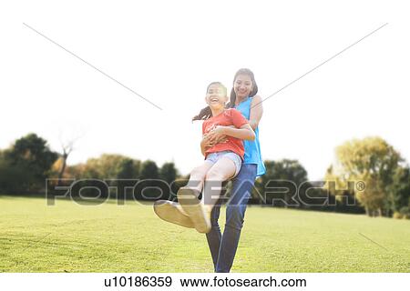 Mother swinging her daughter around View Large Photo Image Stock Photo - Mother swinging her daughter around . Fotosearch
