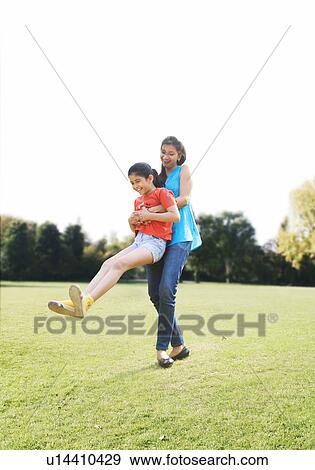 Stock Photo - Mother swinging her daughter around . Fotosearch
