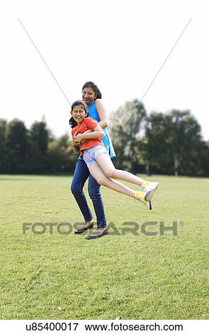 Mother swinging her daughter around View Large Photo Image Stock Photo - Mother swinging her daughter around . Fotosearch