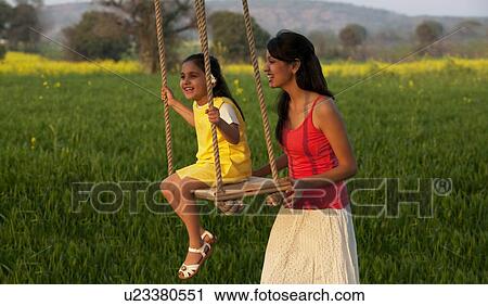 Mother swinging her daughter View Large Photo Image Stock Image - Mother swinging her daughter . Fotosearch