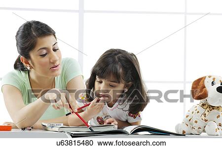 Mother teaching her daughter View Large Photo Image Stock Image - Mother teaching her daughter . Fotosearch