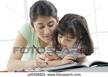 Mother teaching her daughter View Large Photo Image Stock Photography - Mother teaching her daughter . Fotosearch