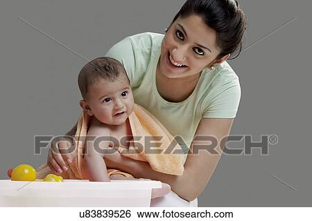 Mother wiping her baby after a bath View Large Photo Image Stock Photograph - Mother wiping her baby after a bath . Fotosearch