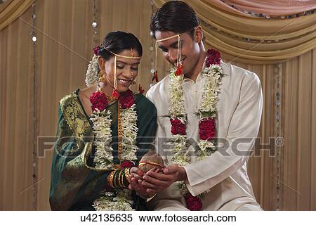 Newlywed couple performing marriage rituals together View Large Photo Image Stock Photography - Newlywed couple performing marriage rituals together . Fotosearch