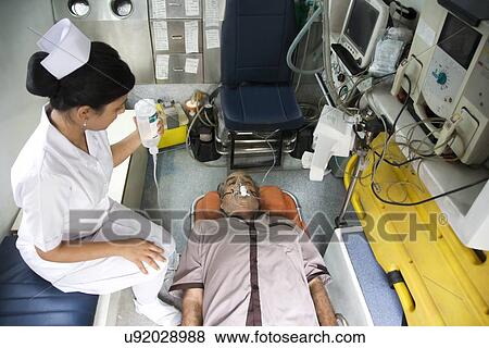 Nurse with a patient inside an ambulance View Large Photo Image Stock Photo - Nurse with a patient inside an ambulance . Fotosearch