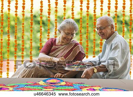Stock Photography - Old couple making a rangoli . Fotosearch