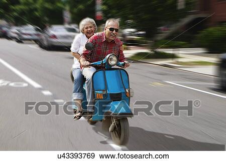 Stock Photo - Old couple on a scooter . Fotosearch