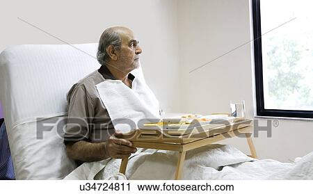 Stock Image - Patient looking out of a window . Fotosearch