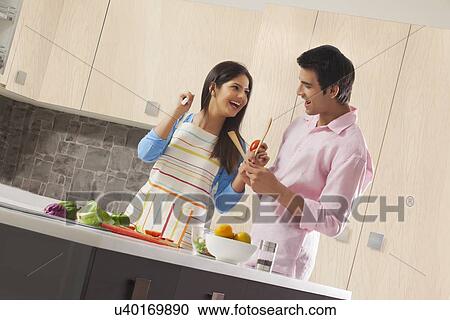 Playful couple preparing healthy salad in kitchen View Large Photo Image Stock Image - Playful couple preparing healthy salad in kitchen. Fotosearch