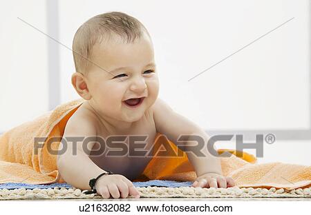Stock Image - Portrait of a baby with a towel . Fotosearch