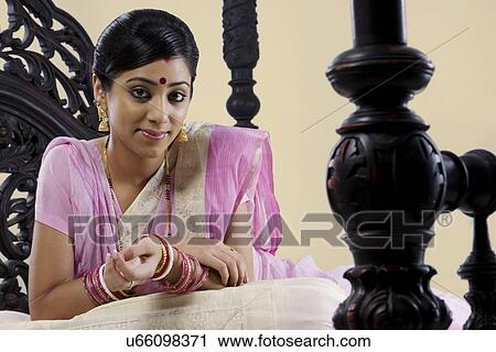 Stock Image - Portrait of a Bengali woman on a bed . Fotosearch