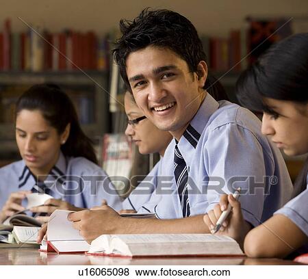 Stock Photo - Portrait of a boy in a school library . Fotosearch