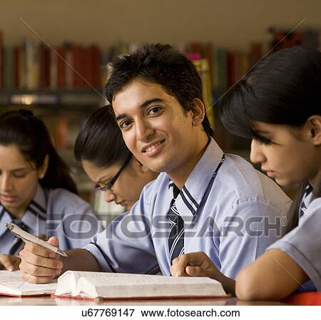 Stock Photo - Portrait of a boy in a school library . Fotosearch
