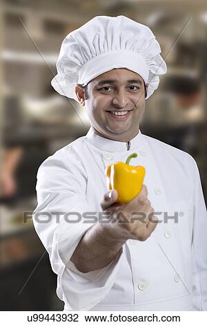 Portrait of a chef holding a yellow bell pepper View Large Photo Image Stock Image - Portrait of a chef holding a yellow bell pepper . Fotosearch