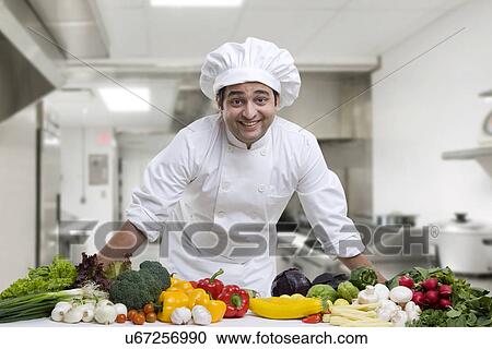 Stock Image - Portrait of a chef with his vegetables . Fotosearch