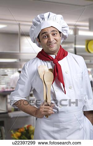 Stock Photo - Portrait of a chef with wooden spoons . Fotosearch