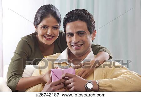 Stock Photo - Portrait of a couple with a gift on Valentines Day. Fotosearch