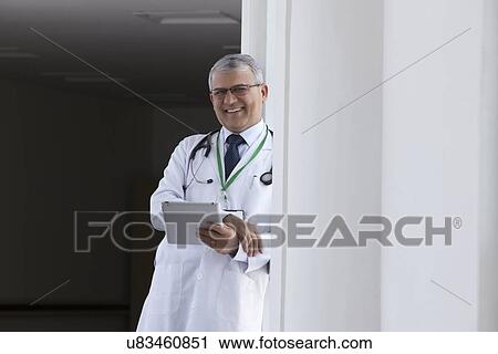 Stock Image - Portrait of a doctor with a digital tablet smiling. Fotosearch