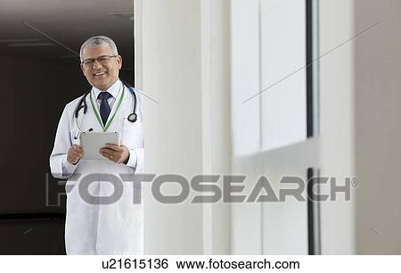 Stock Photograph - Portrait of a doctor with a digital tablet smiling. Fotosearch