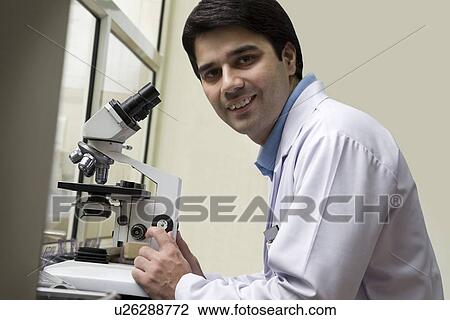 Stock Image - Portrait of a doctor with a microscope . Fotosearch