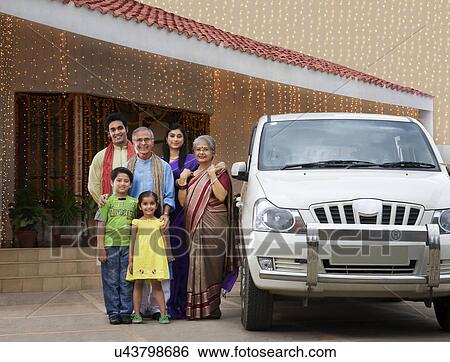 Stock Photograph - Portrait of a family standing with their car . Fotosearch