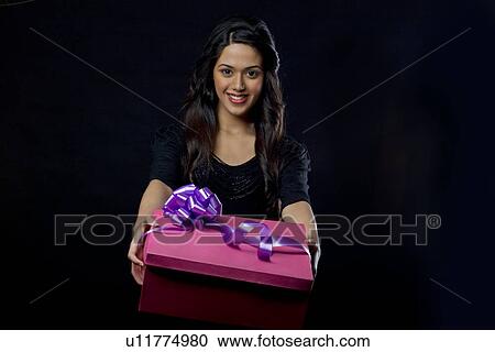 Stock Image - Portrait of a girl holding a gift . Fotosearch