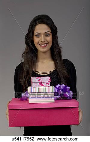 Stock Image - Portrait of a girl holding gifts . Fotosearch