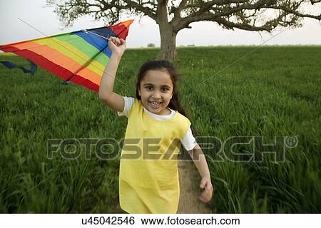 Stock Photograph - Portrait of a girl with a kite . Fotosearch