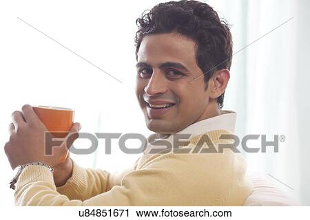 Portrait of a man holding a mug of tea View Large Photo Image Stock Image - Portrait of a man holding a mug of tea. Fotosearch