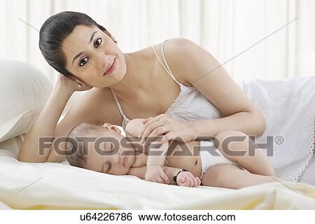 Portrait of a mother with her baby sleeping View Large Photo Image Stock Photograph - Portrait of a mother with her baby sleeping . Fotosearch