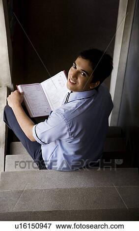 Stock Photo - Portrait of a school boy sitting on the stairs . Fotosearch