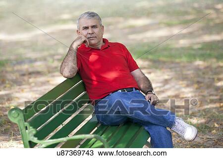 Stock Image - Portrait of a senior man sitting on a bench. Fotosearch