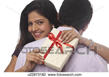 Portrait of a woman holding a gift smiling View Large Photo Image Stock Image - Portrait of a woman holding a gift smiling. Fotosearch