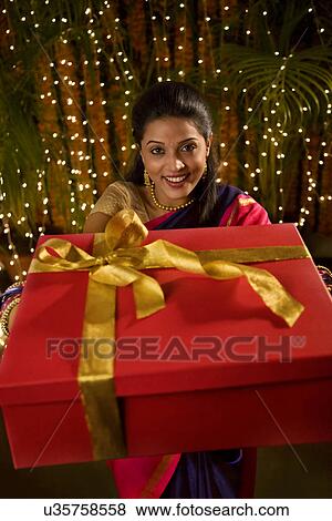 Stock Photo - Portrait of a woman holding a gift . Fotosearch