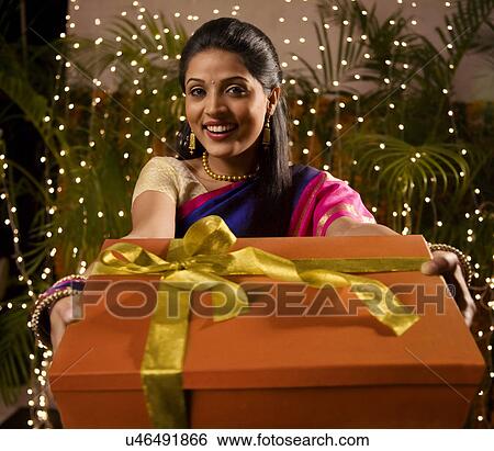 Portrait of a woman holding a gift View Large Photo Image Stock Photograph - Portrait of a woman holding a gift . Fotosearch