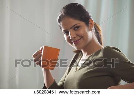Portrait of a woman holding a mug of tea View Large Photo Image Stock Image - Portrait of a woman holding a mug of tea. Fotosearch