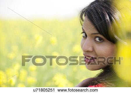 Stock Image - Portrait of a woman in a field . Fotosearch
