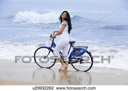 Portrait of a woman with a bicycle at a beach View Large Photo Image Stock Image - Portrait of a woman with a bicycle at a beach . Fotosearch