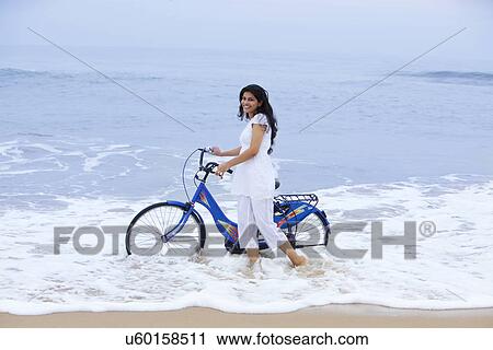 Portrait of a woman with a bicycle at a beach  View Large Photo Image Stock Image - Portrait of a woman with a bicycle at a beach . Fotosearch