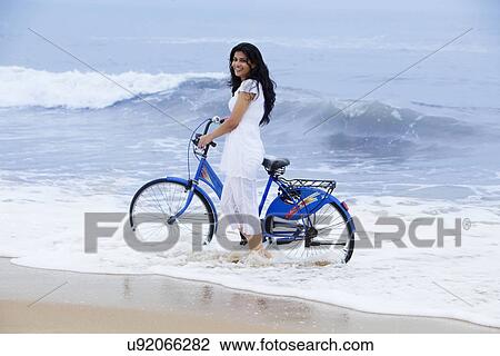 Portrait of a woman with a bicycle at a beach View Large Photo Image Stock Image - Portrait of a woman with a bicycle at a beach . Fotosearch