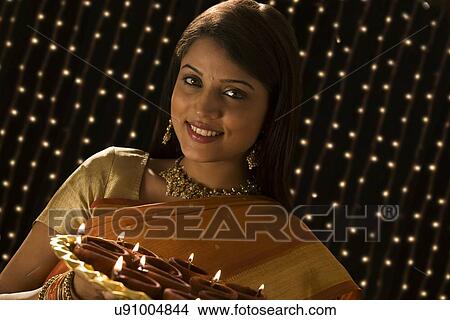 Portrait of a woman with a tray of diyas View Large Photo Image Picture - Portrait of a woman with a tray of diyas . Fotosearch