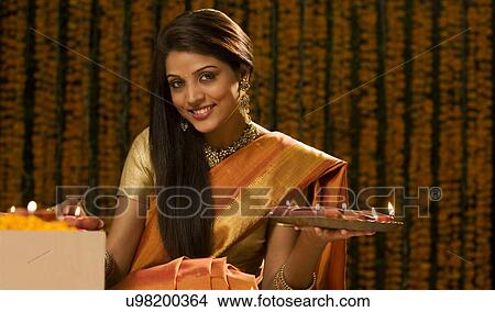 Portrait of a woman with a tray of diyas View Large Photo Image Picture - Portrait of a woman with a tray of diyas . Fotosearch