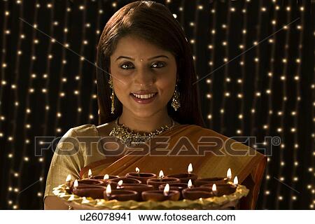 Portrait of a woman with a tray of diyas View Large Photo Image Stock Image - Portrait of a woman with a tray of diyas . Fotosearch