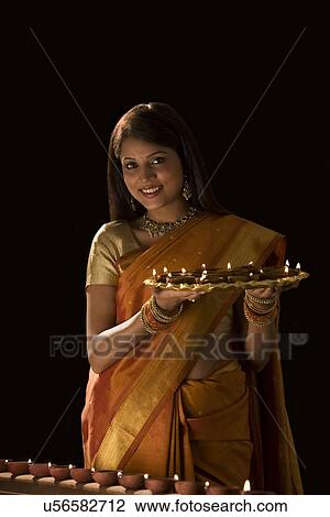Stock Image - Portrait of a woman with a tray of diyas . Fotosearch