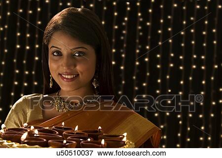 Stock Photo - Portrait of a woman with a tray of diyas . Fotosearch
