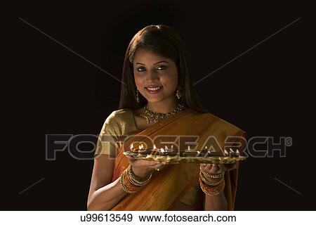 Stock Photo - Portrait of a woman with a tray of diyas . Fotosearch