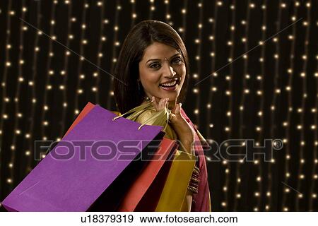 Stock Photo - Portrait of a woman with shopping bags . Fotosearch
