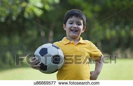 Portrait of a young boy holding a football View Large Photo Image Stock Photo - Portrait of a young boy holding a football. Fotosearch