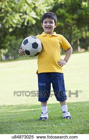 Portrait of a young boy holding a football View Large Photo Image Stock Photography - Portrait of a young boy holding a football. Fotosearch